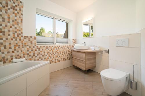 a bathroom with a tub and a toilet and a sink at Selene in Wustrow
