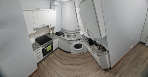 a small kitchen with a washing machine in it at Apartamento Turístico Menéndez Pelayo -Vigo in Vigo