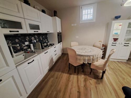 a kitchen with a table and white cabinets at La Fornace di Francesca - Certaldo Alto in Certaldo