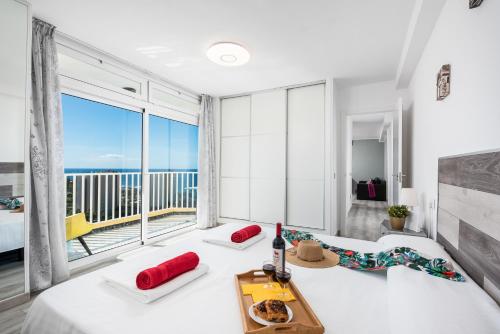a bedroom with a large window with a view of the ocean at Beach apartment in Las Americas in Arona