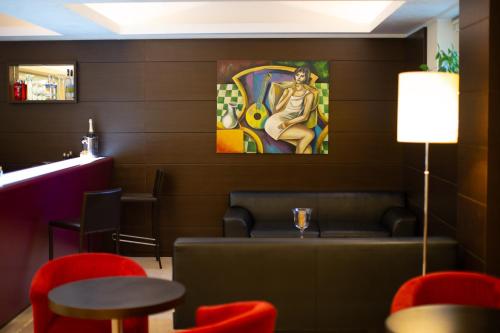 a dining room with red chairs and a painting on the wall at La Dimora del Baco Hotel in LʼAquila