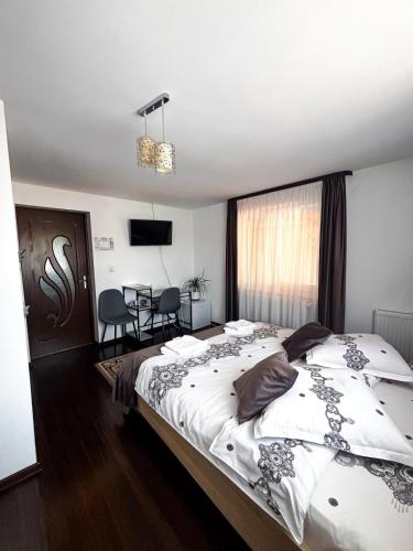 a bedroom with a large bed and a table at Casa Irina in Mănăstirea Humorului