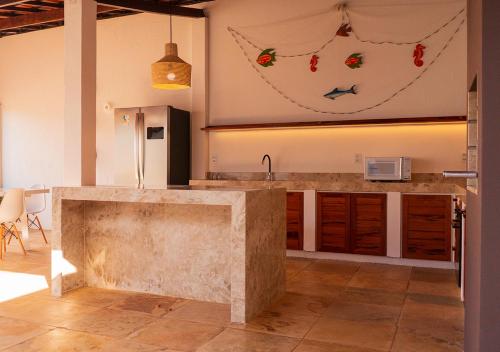 a kitchen with a concrete counter top in a room at Kite Oasis Parajuru Villa Palmeira in Parajuru