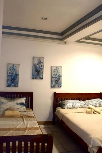 two beds sitting next to each other in a room at Ace Travellers Inn- Palawan in Puerto Princesa City