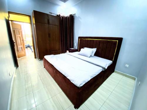 a bedroom with a bed with white sheets and a mirror at SILVER GARDEN KIGALI Kabeza in Kigali