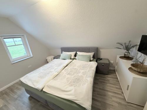 a bedroom with a large bed with a window at Ferienwohnung Haus Moorblick Garten mit Terrasse Netflix E-Kamin Thermomix in Wiesmoor