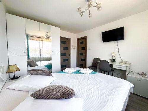 a hotel room with two beds and a tv at Casa Irina in Mănăstirea Humorului