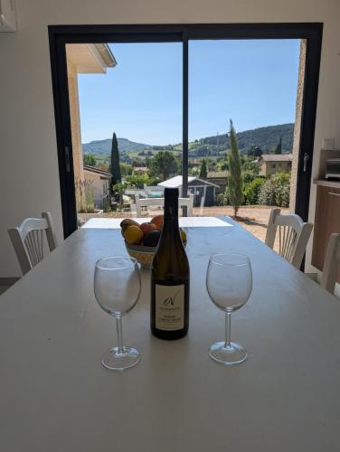 a bottle of wine sitting on a table with two wine glasses at L'échappée Bourguignonne in La Vineuse