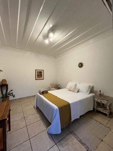 a bedroom with a large white bed in a room at Suites Matriz Centro Histórico in Paraty