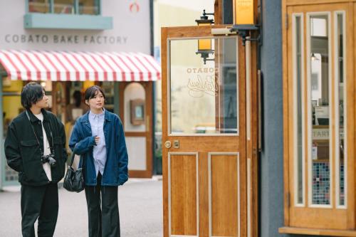 two people standing on a street in front of a store at Guesthouse RICO in Wakayama