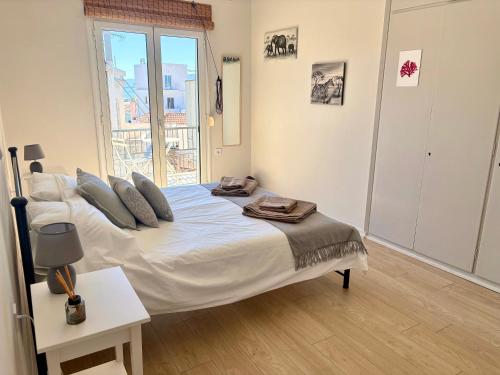 a bedroom with a large white bed with a window at Aegina Heights in Aegina Town