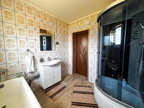 a bathroom with a tub and a sink and a bath tub at Casa Irina in Mănăstirea Humorului