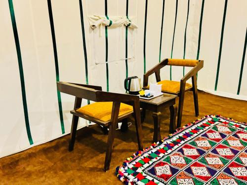 a table and two chairs and a table and a rug at Taj heritage camp& resort in Jaisalmer