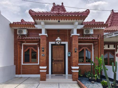 a red brick house with a wooden door at Casa Kusuma in Prambanan