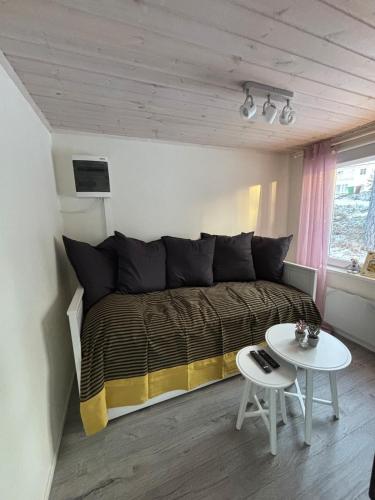 Una cama en una habitación pequeña con una mesa. en Lilla sjölyckan, en Forshaga