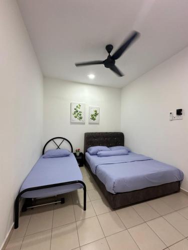 2 camas en una habitación con ventilador de techo en Homestay501, en Kampong Jelatang