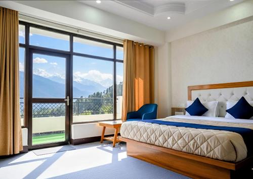 una camera d'albergo con un letto e una grande finestra di Pine Woods Retreat A Premium Room With Balcony By Anvi a Nainital