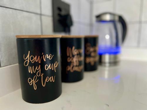 three black cups with writing on them on a counter at Seewindelaan in Scottburgh