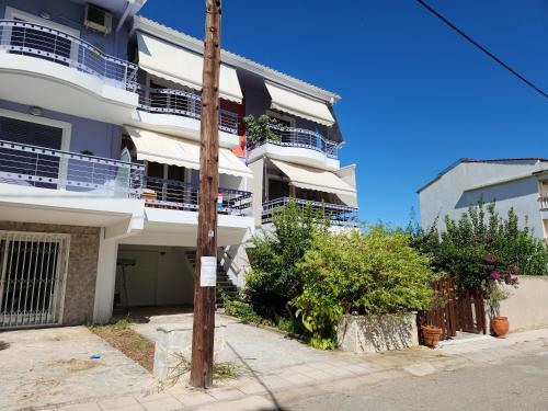 un edificio de apartamentos blanco con balcones y un poste en Akrata Maisonette, en Akráta