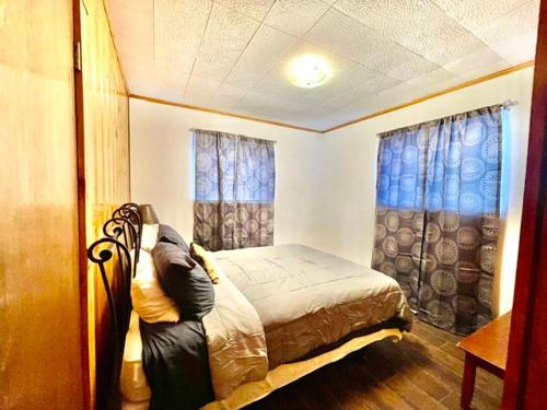 a bedroom with a bed and two windows at Cozy Cabin Retreat in Midway in Mound City