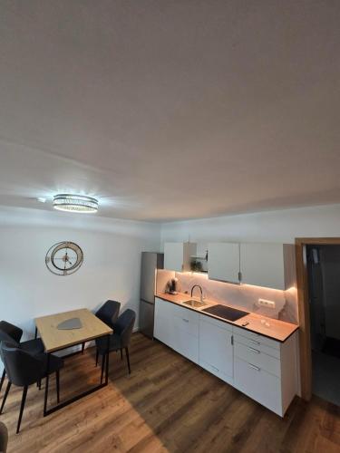 a kitchen and dining room with a table and a sink at Ländle Lodge, Ferienwohnung nahe Bregenz, Lindau und Bodensee in Hohenweiler