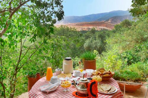 a picnic table with food and a view of the mountains at MAROC LODGE Atlas Mountain Retreat in Amizmiz