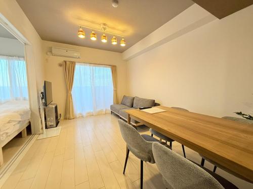 a living room with a dining table and a bed at Sun Court Nango-dori サンコート南郷通 1003 in Sapporo