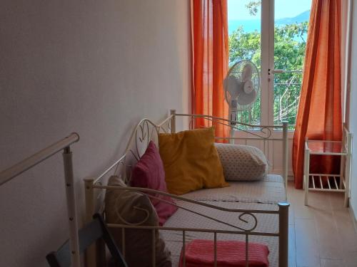 een bed met kleurrijke kussens in een kamer met een raam bij Appartamento con vista sul Golfo in Lerici