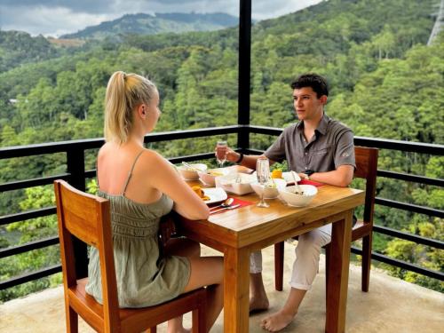a man and a woman sitting at a table eating food at Aqua Dunhinda Nature Retreat in Kandy