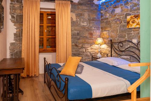 a bedroom with a bed and a stone wall at Wine House Rakar in Gračišče