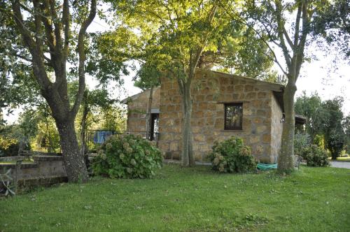 a stone house in a yard with trees at Agriturismo Buriano in Lubriano