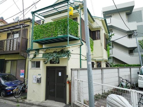 a apartment building with a balcony and a door at 7時IN19時OUT # 池袋王子赤羽駅無料送迎 # テラスハウス # 駅近10分 # 上野駅電車12分 # 最大7名 # 7 00 IN19 00 OUT # Free pick-up at Ikebukuro, Oji, and Akabane Stations # Terrace House # 10 min to station # 12 min to Ueno # Max 7 in Tokyo