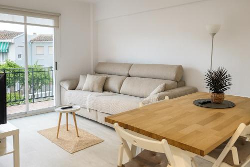 un soggiorno con un tavolo e un divano di Playa y Comodidad en Benicàssim a Benicàssim