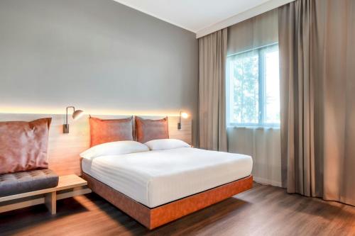 a bedroom with a large bed and a window at Moxy Verona in Verona