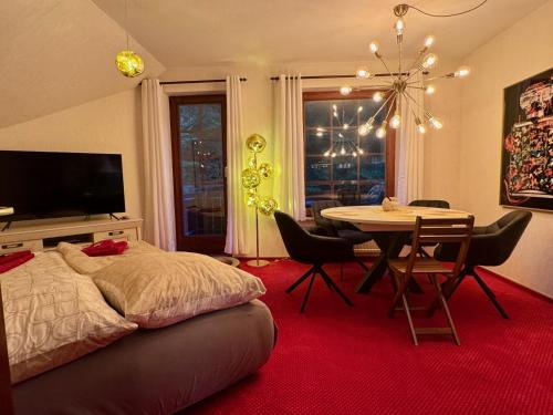 a bedroom with a bed and a table with chairs at Harztastisch Ferienwohnung in Bad Sachsa