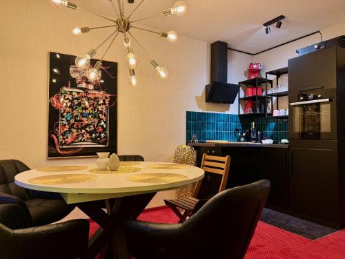 a dining room with a table and a kitchen at Harztastisch Ferienwohnung in Bad Sachsa