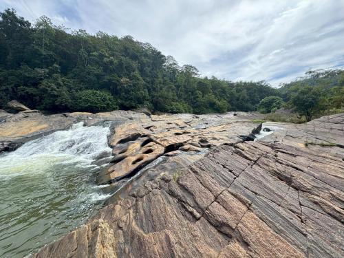 a river with water rushing over the rocks at Aqua Dunhinda Nature Retreat in Kandy