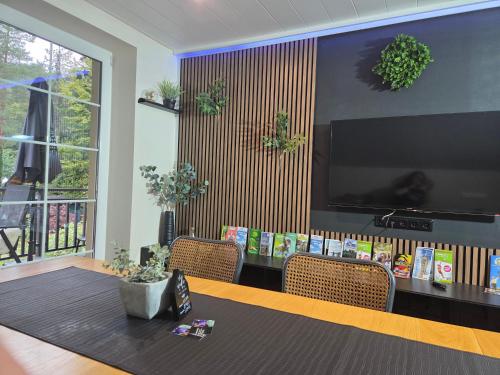 a dining room with a table and a large television at Ferienwohnung Rosi in Sankt Ulrich
