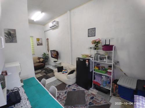 a living room with a refrigerator and a couch at Sri Nawa Homestay in Pokok Sena