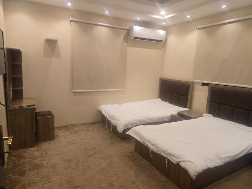 a room with two beds and a projection screen at Marasi in AlUla