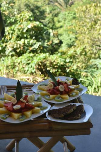 two plates of food on a wooden table at Hotel Peace & Lodge in Sámara