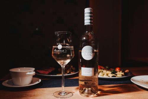 a bottle of wine next to a glass on a table at Hotel Graf Bentinck in Dangast