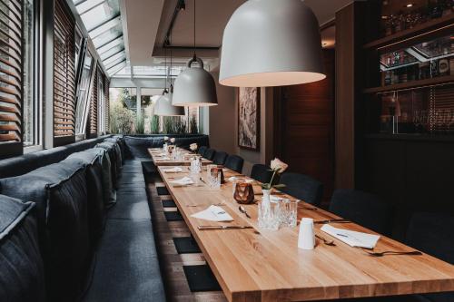 a long wooden table in a restaurant with black chairs at Hotel Graf Bentinck in Dangast