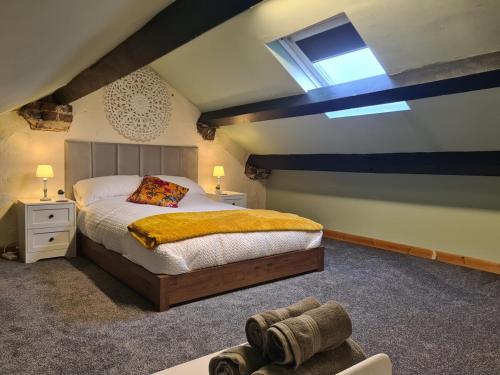 a bedroom with a large bed and a skylight at Cosy Townhouse Within Caernarfon's Old Town Walls in Caernarfon