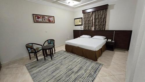 a bedroom with a bed and a table and chairs at درة الصالحين للشقق المخدومة in Makkah