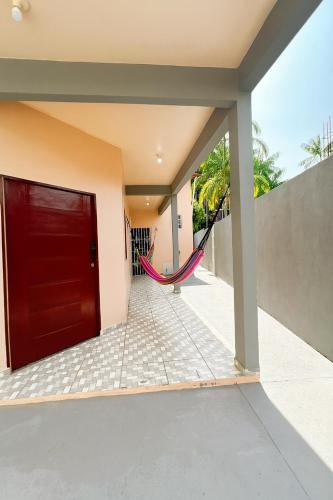 マカパにあるCasa Amazônia Comfort and Nature in Macapáのハンモックのある家の赤いドア