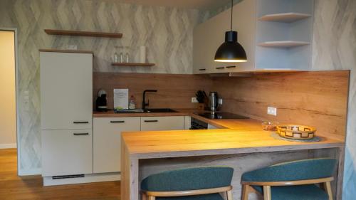 a kitchen with a wooden counter and two chairs at GW Apartment 2 in Meppen
