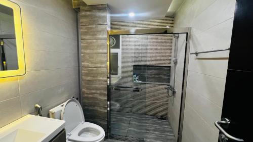 a bathroom with a shower with a toilet and a sink at Skyline Hotel Apartments-Elysium Tower Facing Centaurus Mall Islamabad in Islamabad