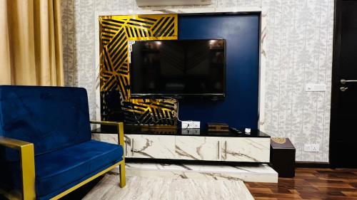 a living room with a blue chair and a tv at Skyline Hotel Apartments-Elysium Tower Facing Centaurus Mall Islamabad in Islamabad