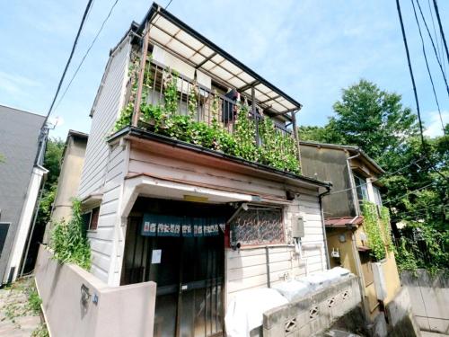 a building with a balcony with plants on it at 7時IN19時OUT # 池袋王子赤羽駅無料送迎 # 上野駅14分 # 日暮里駅10分 # 一棟貸切 # 最大7名 A # 7 00 IN19 00 OUT # Free pick up Ikebukuro Oji and Akabane Stations # 14 min to Ueno # 10 min to Nippori # Whole house rental # Max 7 # A in Tokyo